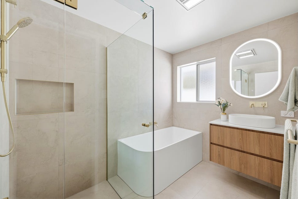 Completed bathroom with freestanding bath, glass shower and timber vanity